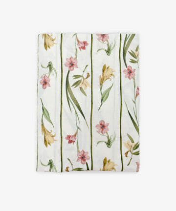 Gladioli Tablecloth—a folded white tablecloth with a gladioli design, showcasing pink and yellow flowers with green leaves in vertical lines. Ideal for adding vibrant style to your table decor.