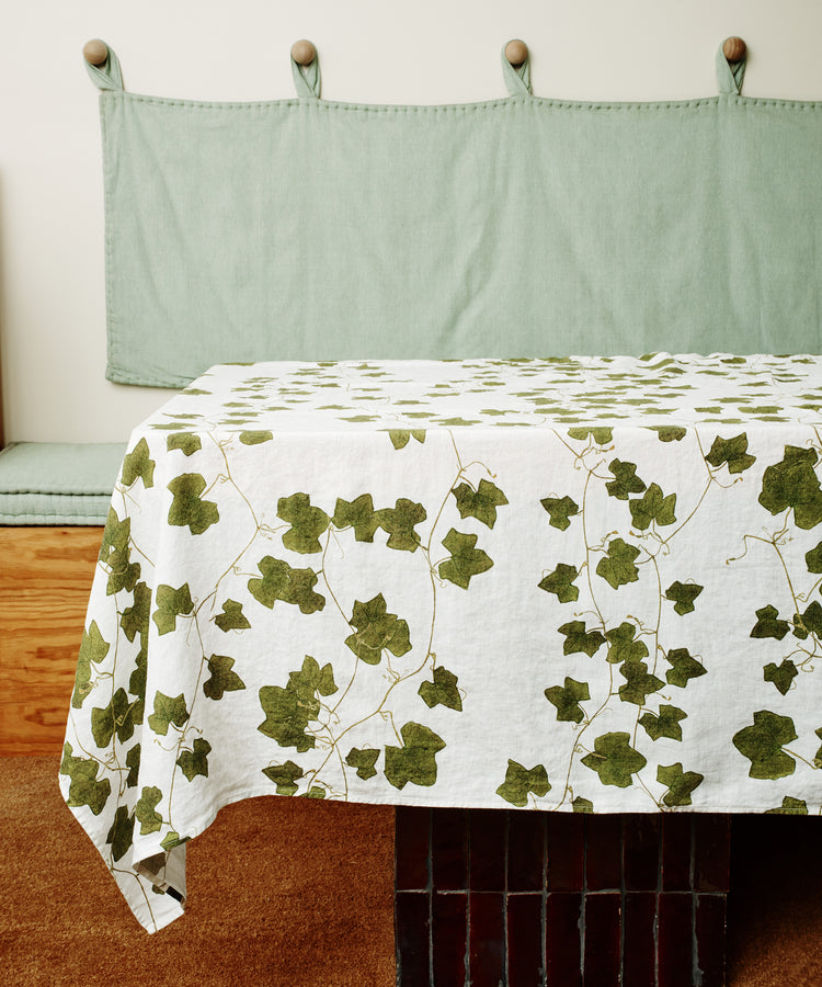 Ivy Herbarium Tablecloth. Image of tablecloth draped over a table. Side view.