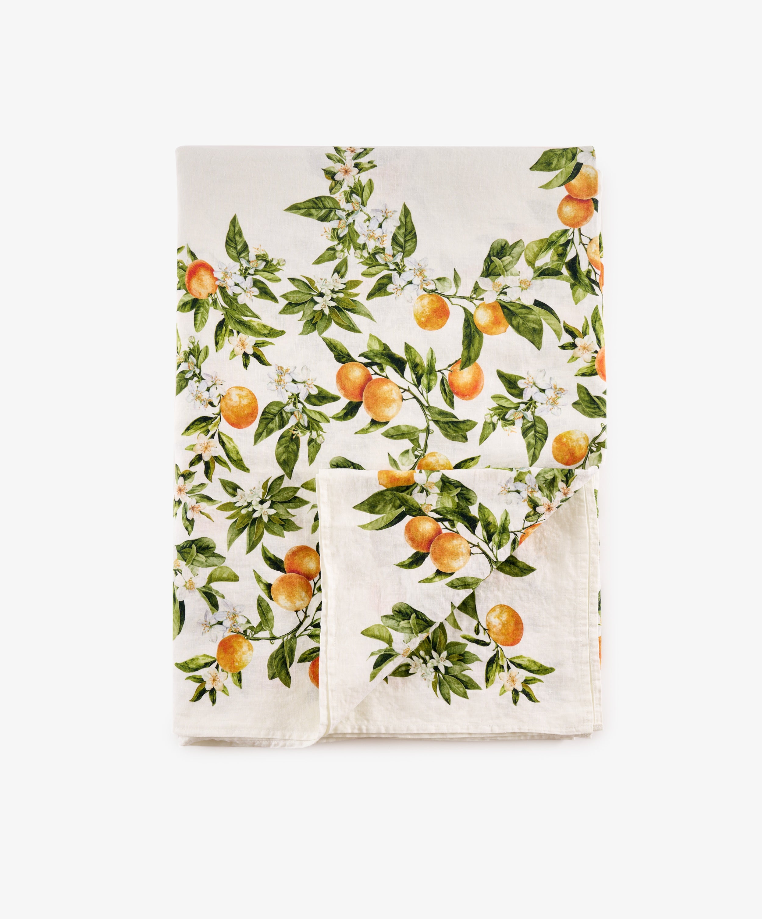 The L’Orangerie Linen Tablecloth, crafted from white French linen and adorned with a vibrant orange fruit and green leaf pattern, is shown neatly folded with one corner turned up against a plain white background—an ideal choice for bringing classical French garden elegance to your table setting.