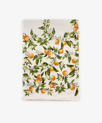 The L’Orangerie Linen Tablecloth, crafted from white French linen and adorned with an orange fruit and green leaf pattern accented by delicate branches and blossoms reminiscent of a classical French garden, is shown laid flat against a white background—perfect for creating an elegant table setting.