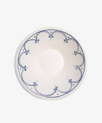 Overhead view of Arco serving bowl, in white glazed ceramic with dark blue handpainted border design.