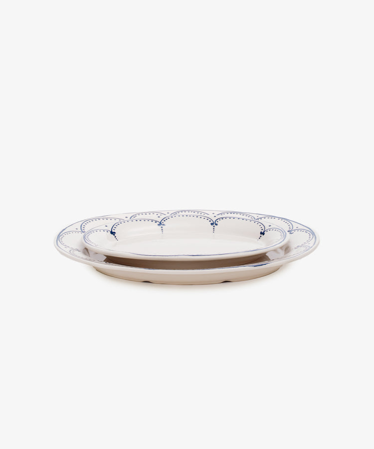 Side view of two sizes of Arco oval serving platters, nested on top of one another.