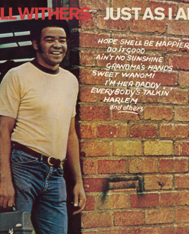 black man leaning on brick wall