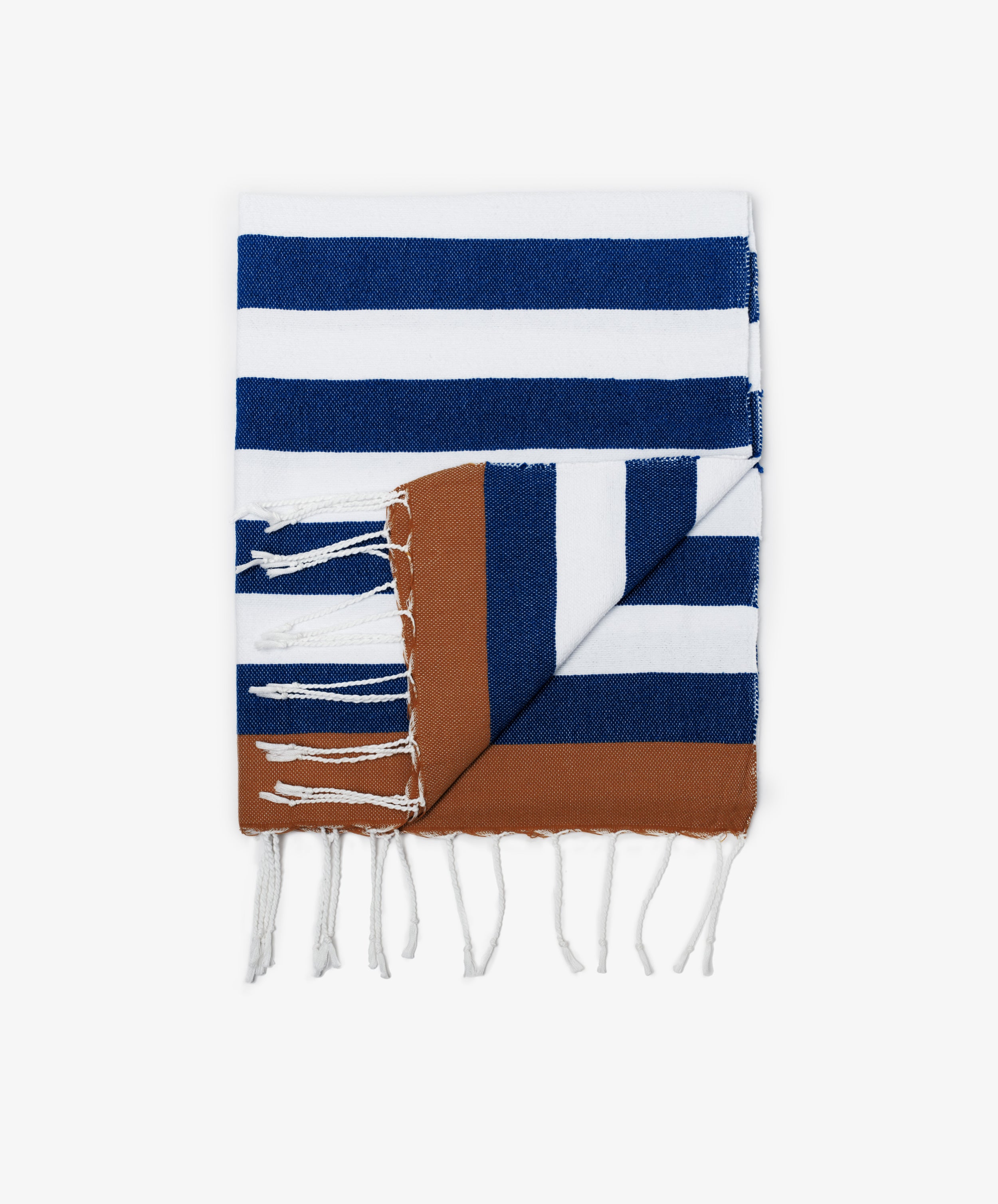 The La Plage Towel is a versatile beach towel, boasting blue, white, and brown stripes with decorative white tassels along the edge.