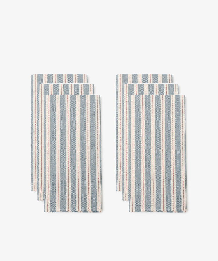 A set of six Martin Striped Napkins with vertical blue and white stripes is arranged in two neat groups on a white background.