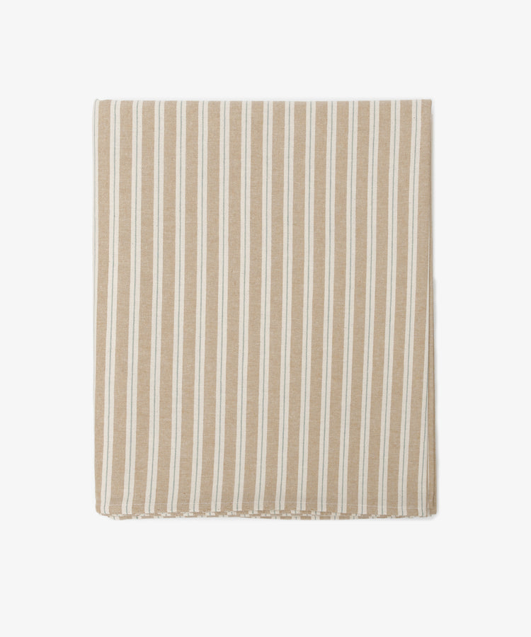 The Martin Striped Tablecloth features classic beige and white stripes inspired by English ticking, displayed neatly folded on a white background.