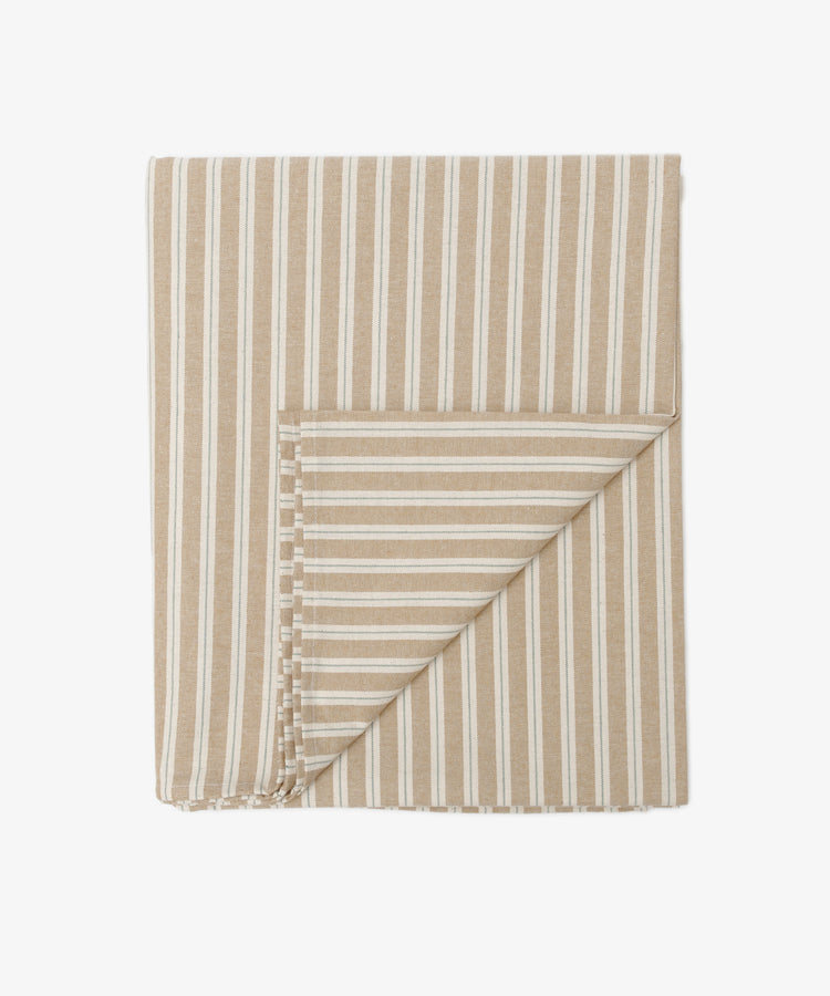 Martin Striped Tablecloth in beige and white English ticking, shown folded with a turned corner to highlight its classic stripes on both sides. Durable and timeless, its ideal for those who appreciate elegant table linens.