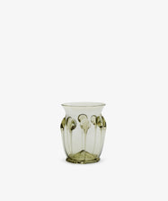 The Carlotta Vase is a translucent, mouth-blown piece with a pale green tint and raised vertical patterns along its sides, displayed against a plain white background.