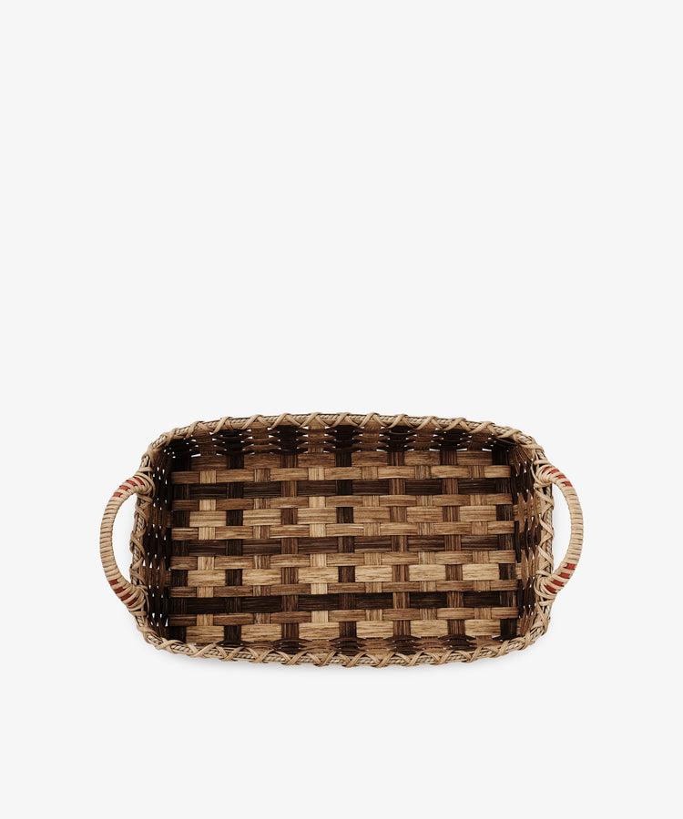 The Folk Fleur Breakfast Tray is a rectangular, handwoven basket with two handles and a checkered light and dark brown reed pattern, shown elegantly on a white background.