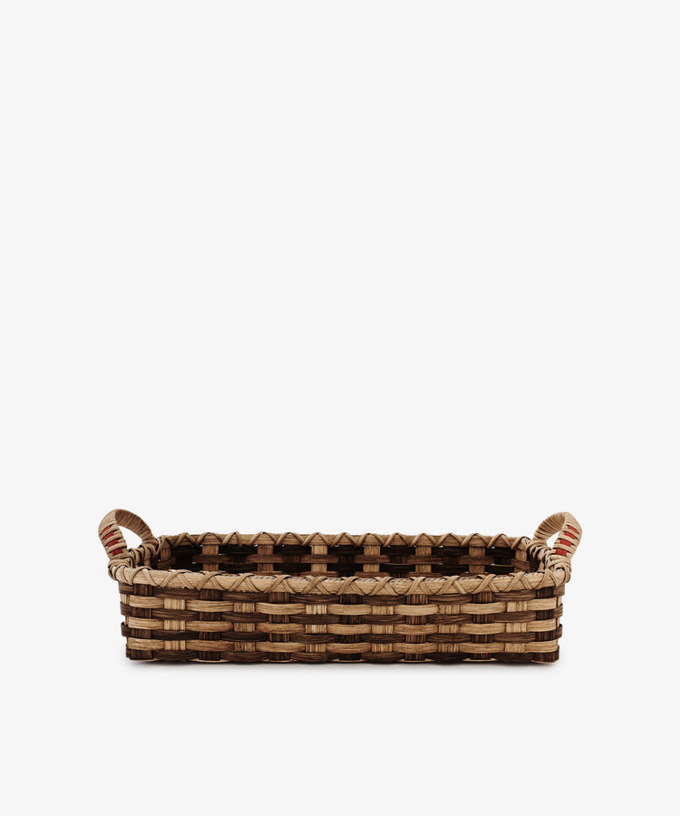 The Folk Fleur Breakfast Tray features a rectangular woven reed design in light and dark brown, two handles, and a patterned rim. Presented on a white background.