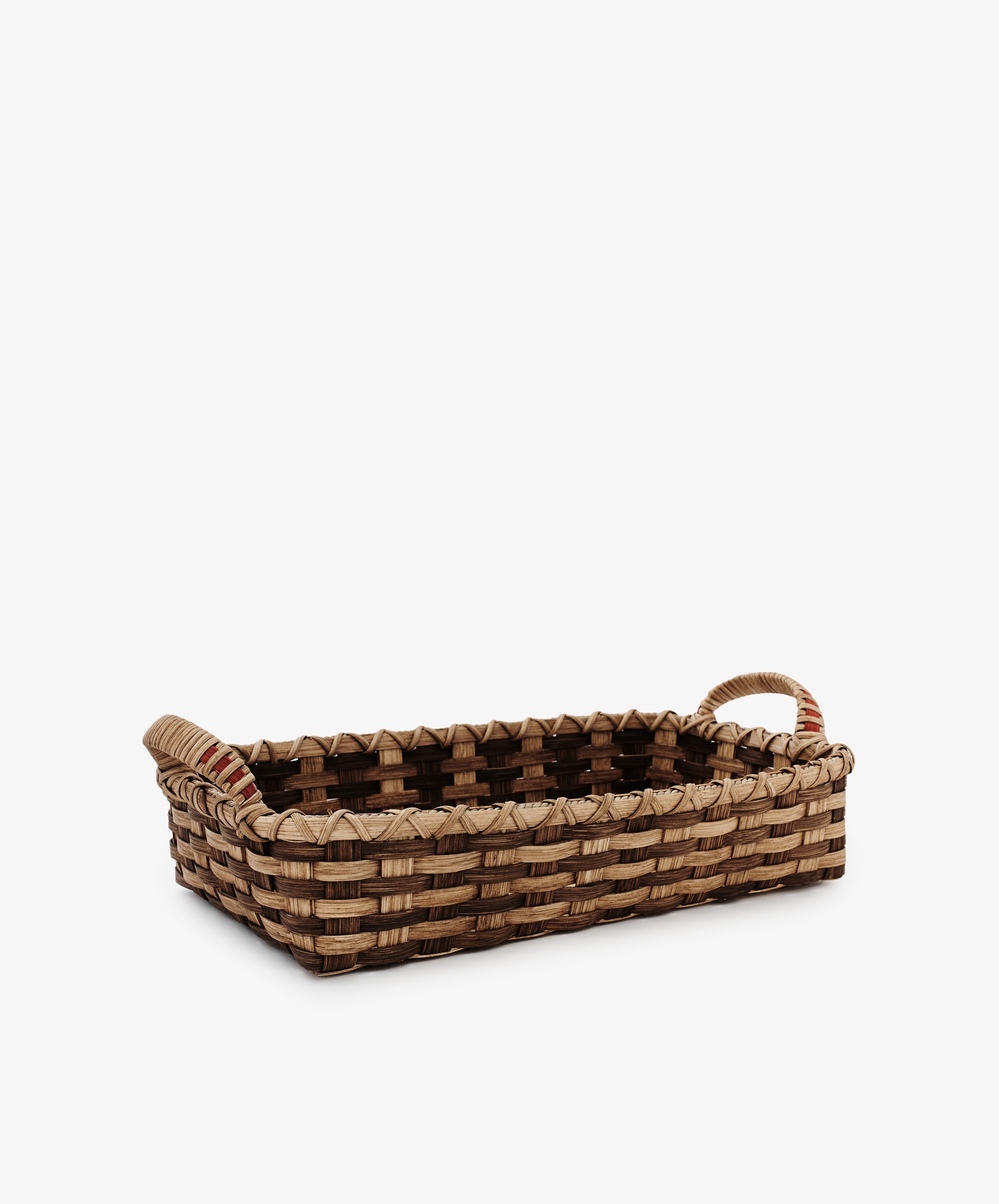 The Folk Fleur Breakfast Tray is a rectangular, handwoven reed basket with two handles, crafted from natural materials and shown on a plain white background.