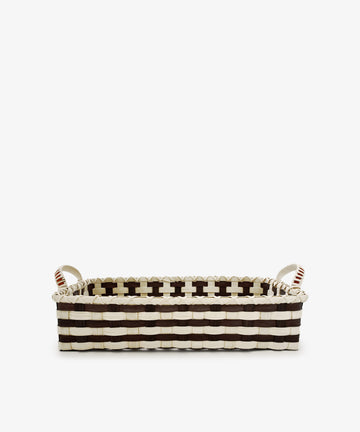 The Folk Fleur Breakfast Tray, featuring a black and white woven pattern and two sturdy handles, is handwoven to capture rustic basketware charm while combining style with everyday practicality. Photographed on a plain white background, this rectangular basket makes an elegant and functional addition to your home.