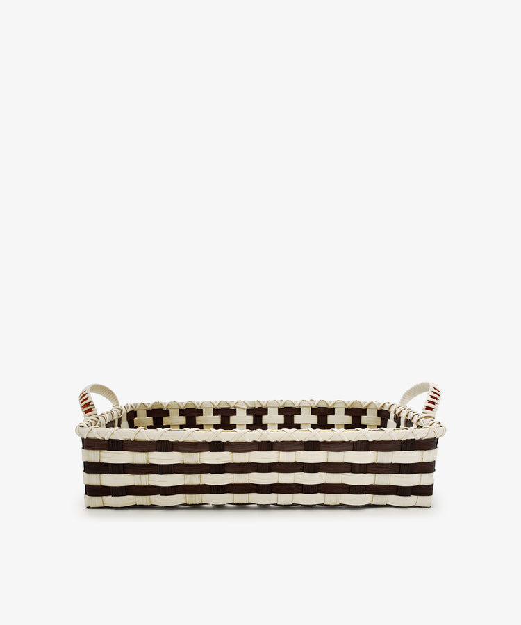 The Folk Fleur Breakfast Tray, featuring a black and white woven pattern and two sturdy handles, is handwoven to capture rustic basketware charm while combining style with everyday practicality. Photographed on a plain white background, this rectangular basket makes an elegant and functional addition to your home.