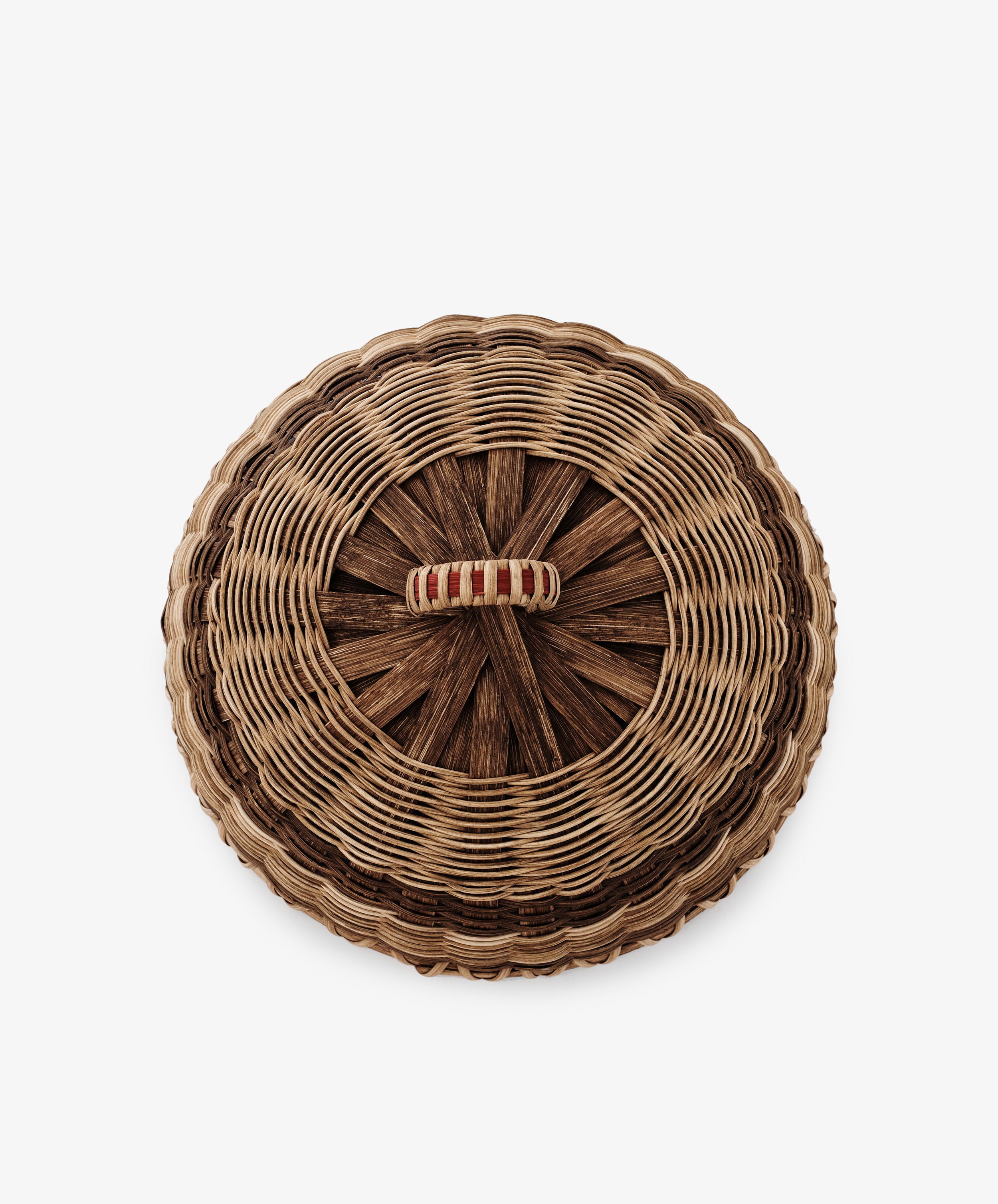 The Folk Fleur Cloche is a round, handwoven basket with a lidded top and a beige-and-red wrapped central handle—ideal for outdoor entertaining. Shown in an overhead photo on a white background.