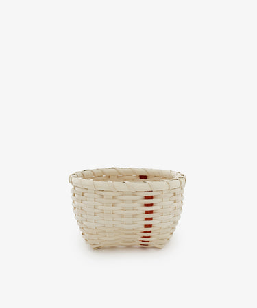 The Little Love Basket is a small handwoven basket in natural beige with a single vertical red stripe, shown on a plain white background.