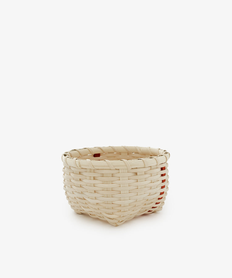 The Little Love Basket, a small round handwoven basket crafted from light-colored material, is displayed against a white background.
