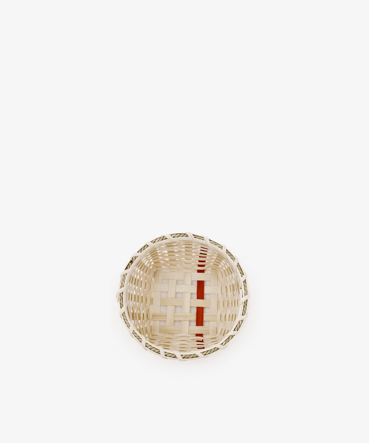 The Little Love Basket, a small, round handwoven piece featuring natural and red accents, is centered on a plain white background.