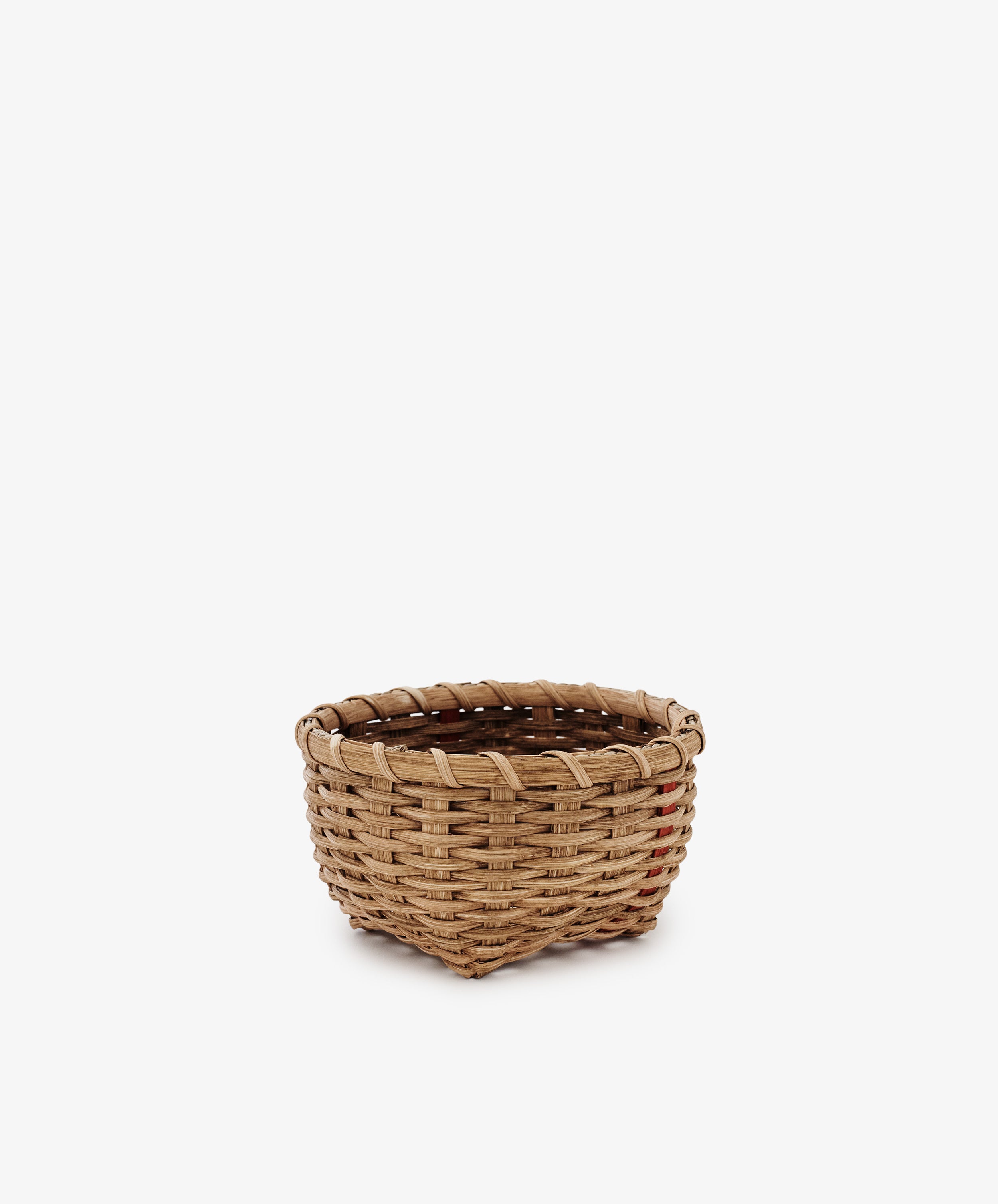 The Little Love Basket, a small empty handwoven piece crafted from natural materials, is displayed on a plain white background.