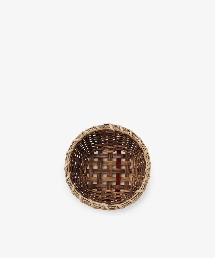 The Little Love Basket is a small, empty handwoven basket crafted from light and dark natural fibers, shown from above on a white background.