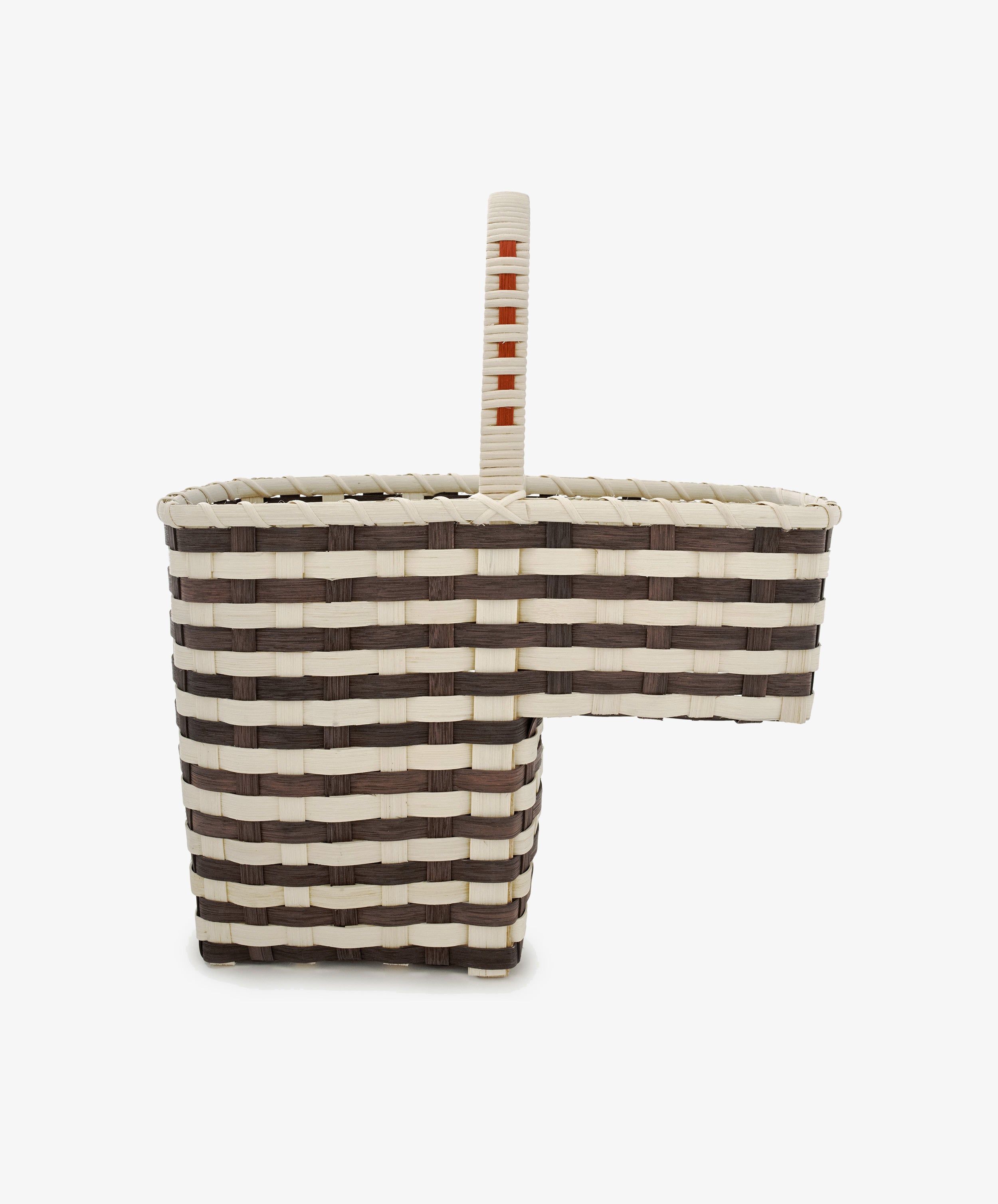 Introducing the Stair Tote—a handwoven basket designed for your staircase, featuring alternating cream and brown bands, a central handle, and a rectangular cutout on one side for easy access and elegant storage.
