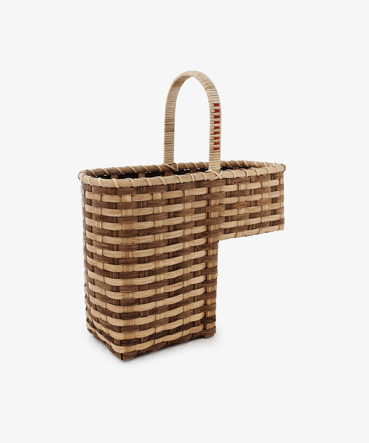 Woven basket with a handle on a white background