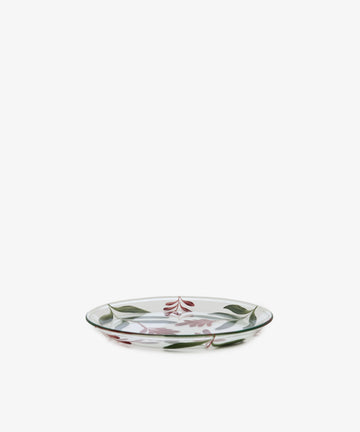 The Botanical Little Plate, a clear glass plate adorned with a hand-painted green and red floral and leaf design, serves as an eye-catching dish displayed against a plain white background.