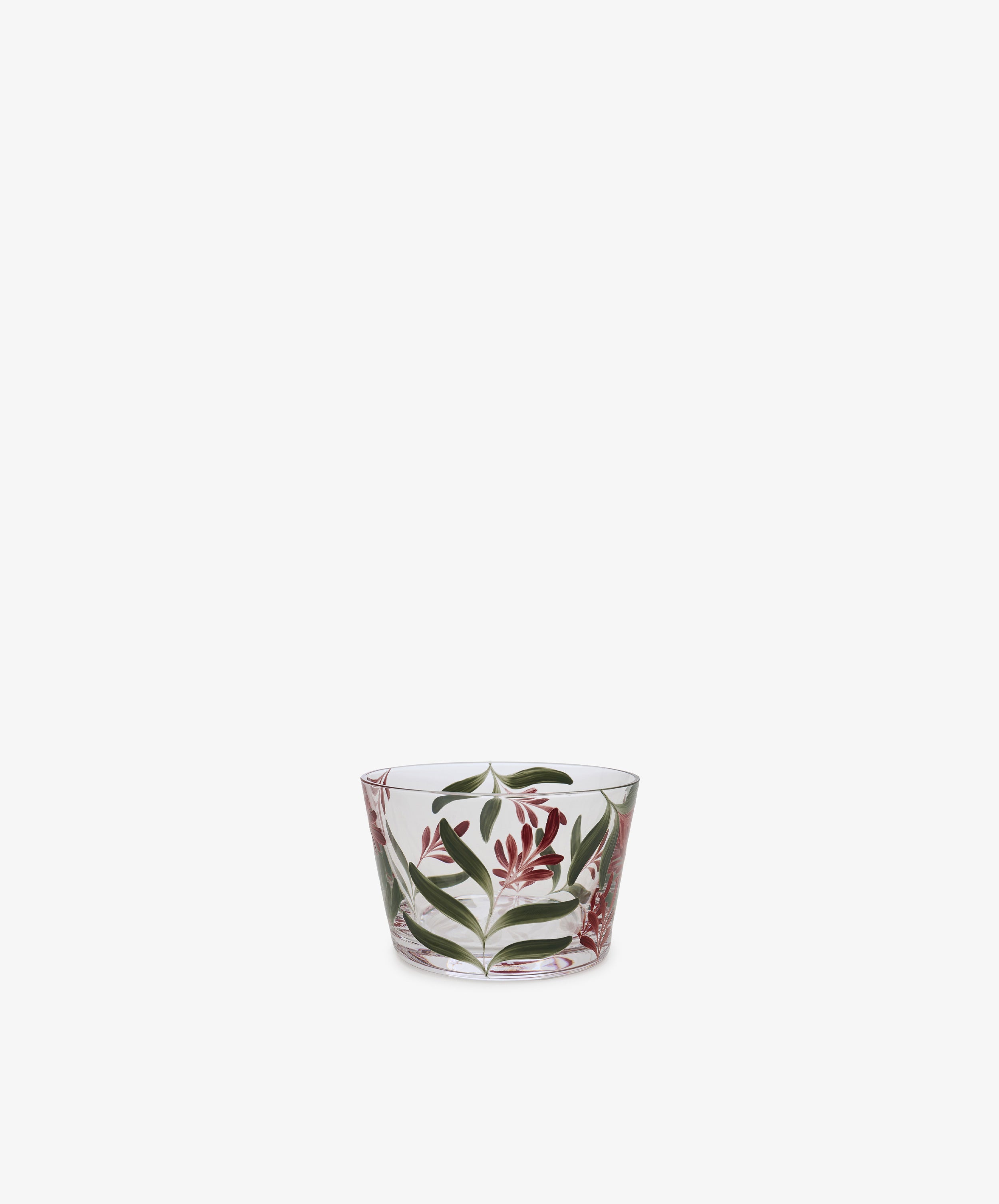 The Botanical Pinch Pot, a small clear glass vessel hand-painted with green leaves and red flowers, is centered against a plain white background—an enchanting tabletop accent.