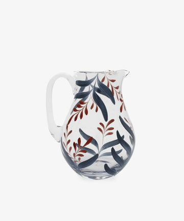 The Botanical Jug is a clear glass pitcher with a handle, featuring unique blue and red leaf patterns—perfect as a hand-painted piece to enhance your tableware collection.