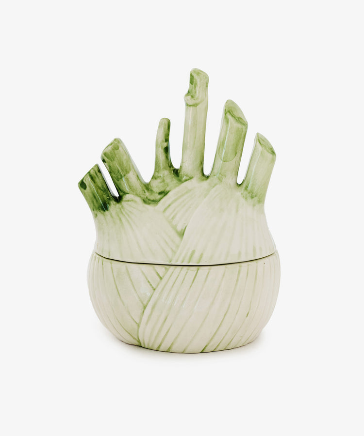 The Fennel Sauce Bowl is a ceramic serving piece shaped like a fennel bulb, featuring a matching lid and light green accents, inspired by skilled Italian ceramicists.