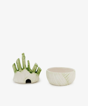 The Fennel Sauce Bowl sits beside another ceramic serving piece with upright, finger-like shapes, green accents, and a small base opening—evoking designs by Italian ceramicists.