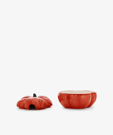 A tomato-shaped ceramic bowl with its lid removed, revealing the open interior and the lid placed beside it on a white background—perfect for adding a touch of trompe l'oeil ceramics charm to your country house kitchen.