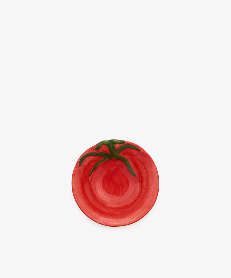 Introducing the Tomato Bowl: a small ceramic dish painted red with a green stem motif to mimic the look of a ripe tomato. Placed on a plain white background, its overripe glaze lends rustic charm to this whimsical piece—perfect as a playful accent atop any Italian farmhouse sideboard.