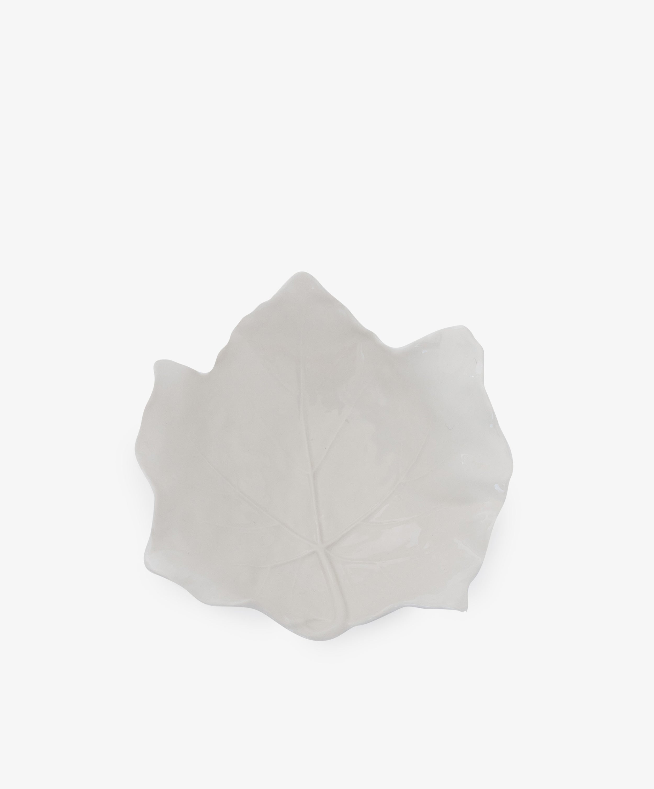 The Leaf Serving Bowl is a white ceramic bowl shaped like a leaf, featuring visible vein details that evoke an Italian countryside table, displayed against a plain white background.