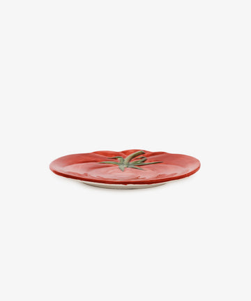 The Tomato Small Plate is an earthenware piece inspired by Mediterranean tableware, featuring a red tomato design with a green stem on a plain white background.