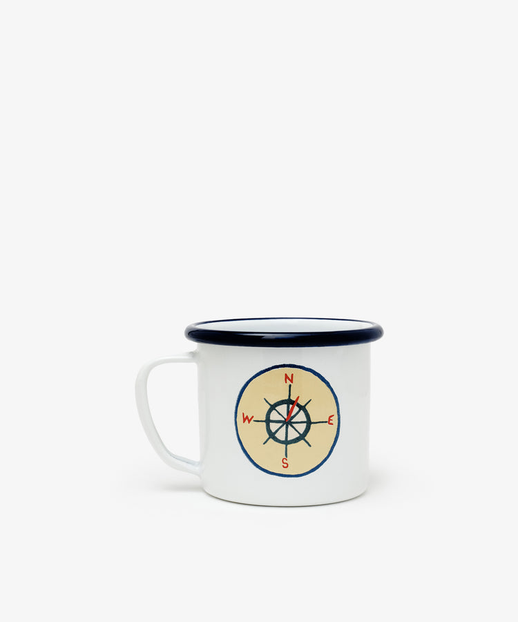 The Camp Cups, Set of 4 are white enamel mugs with blue rims and a compass design in red and black—perfect for adding vintage scout badge style to your kids’ tableware or pairing with enamel plates.