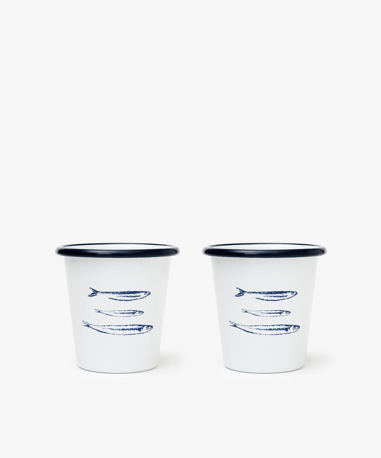 The Il Pesce Enamel Cup Set of 2 features lightweight, durable cups with blue rims and three sardine fish illustrations, making them a charming addition to any mug collection.