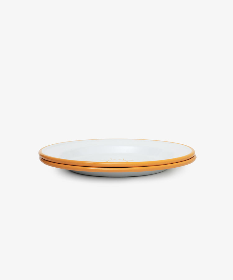 The Il Sole Enamel Plate, Set of 2, features two white ceramic plates with sunny yellow rims stacked on a plain white background, evoking the feel of summer tableware.