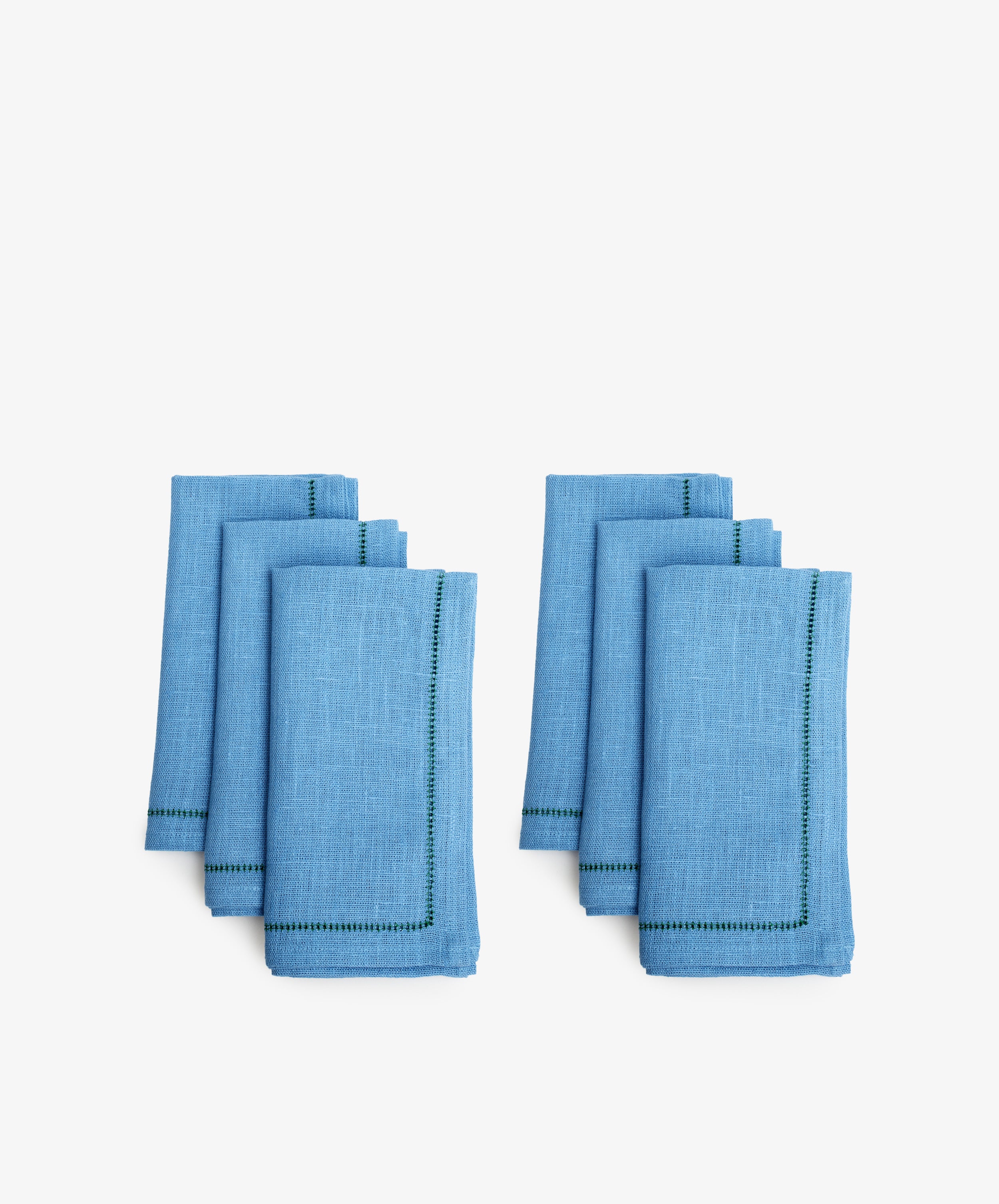 Magnetic Color Field Napkin. Two rows of three folded rectangular napkins in blue linen with stitching.