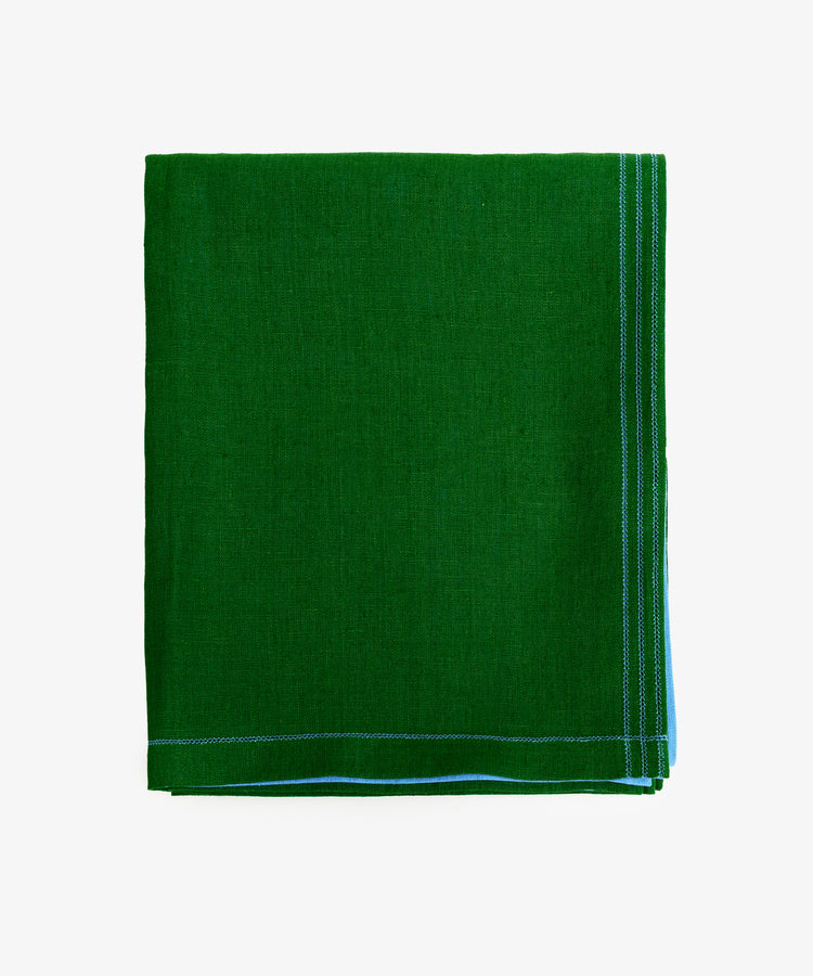 Magnetic Color Field Tablecloth. Folded green linen cloth with blue stitching.