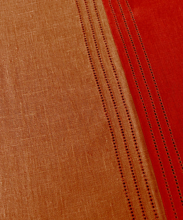 Close-up of Magnetic Color Field Tablecloth, in terracotta and red linen with stitching.