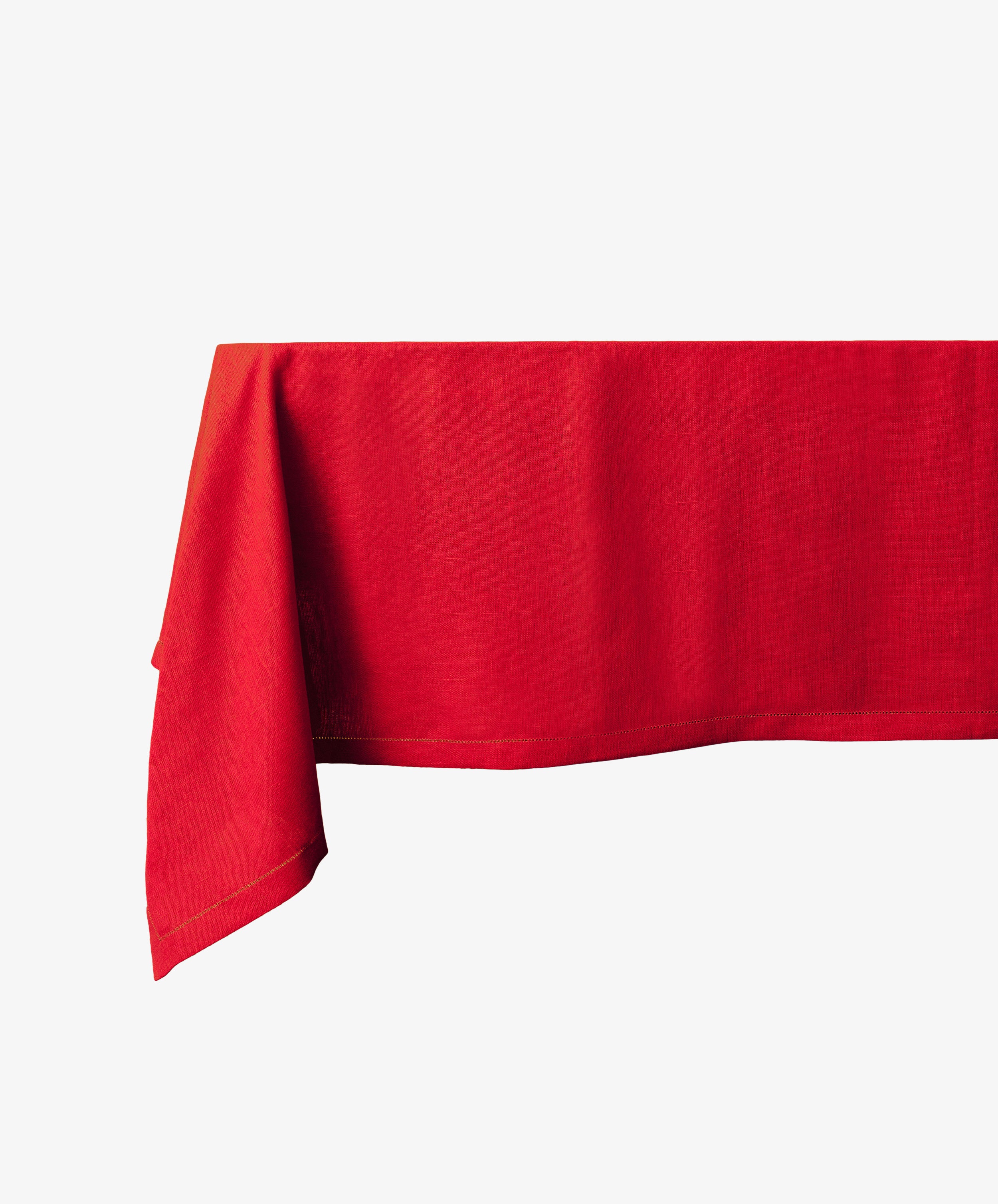 A rectangular Magnetic Colorfield Tablecloth in red linen drapes over a table against a plain white background, highlighting its sustainable craftsmanship.