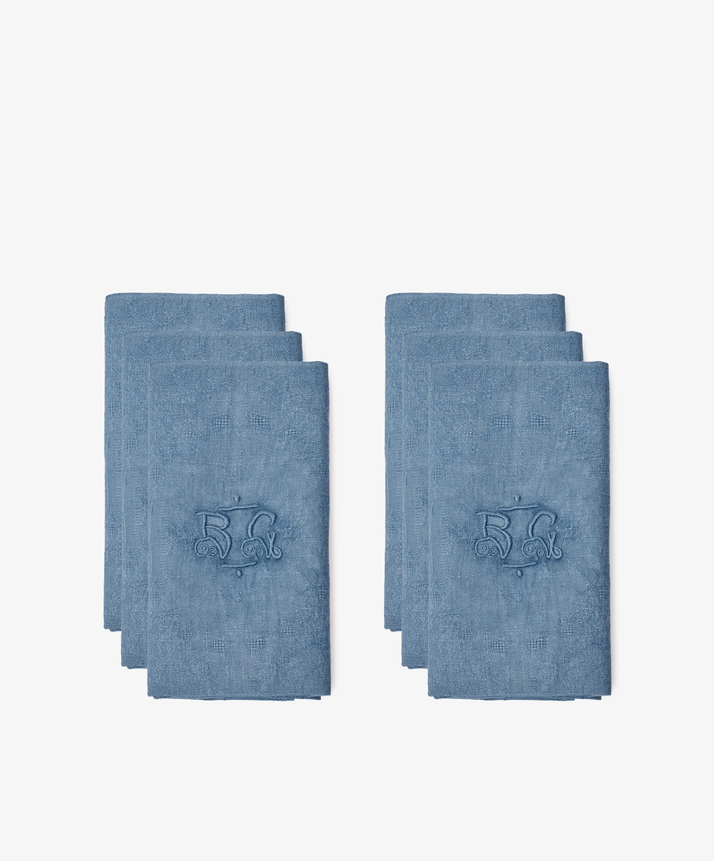 Two stacks of Vintage Embroidered Napkins, Set of 6, each blue and French linen with the number 52 and a decorative design, are displayed on a white background.