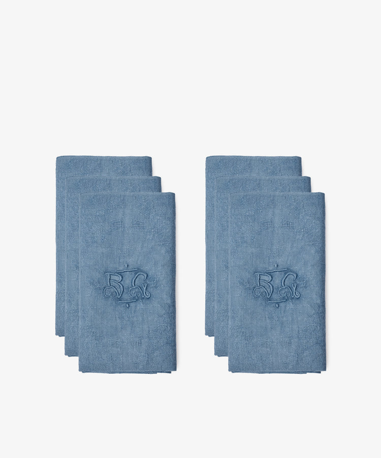 Two stacks of Vintage Embroidered Napkins, Set of 6, each blue and French linen with the number 52 and a decorative design, are displayed on a white background.