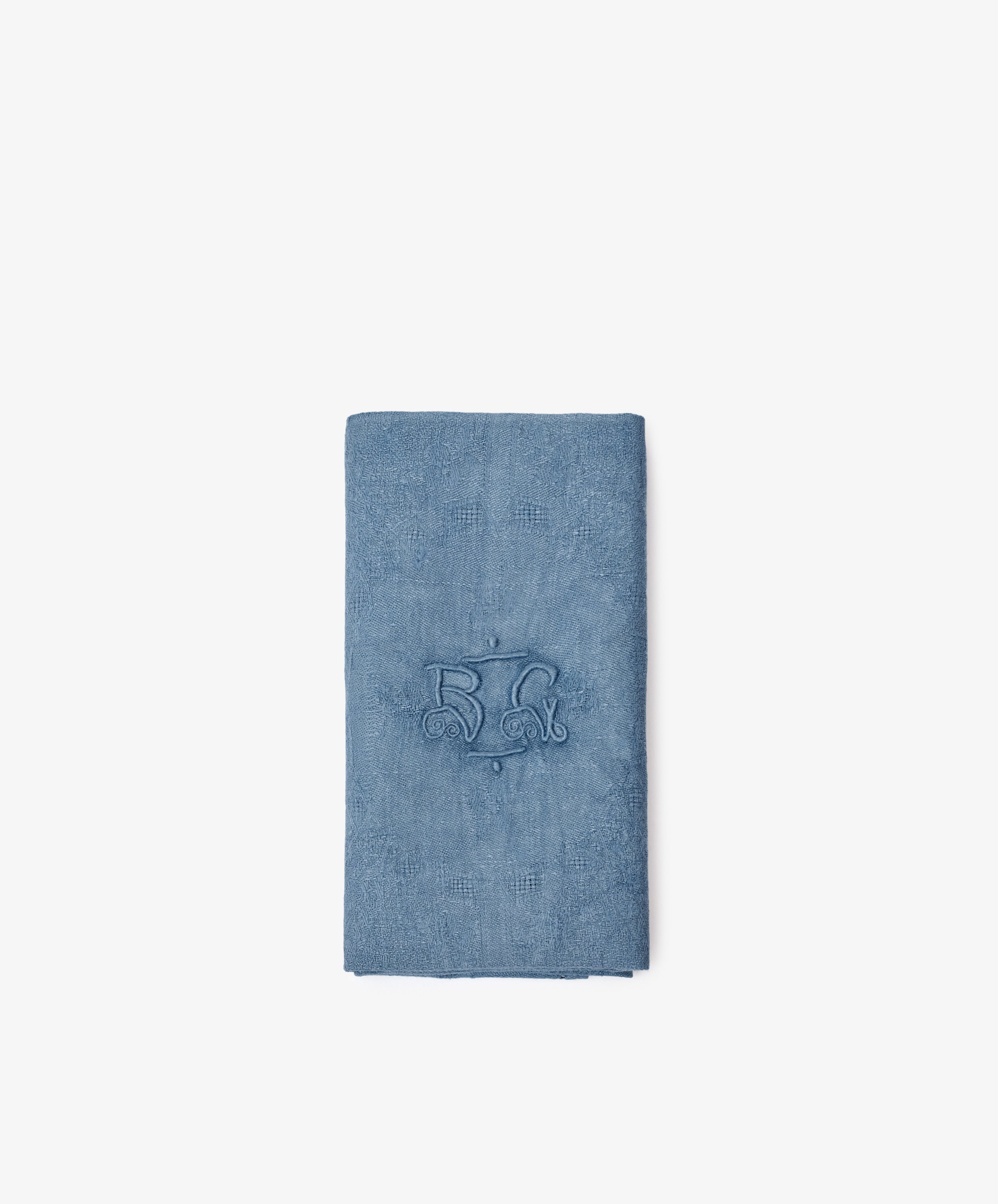 The Vintage Embroidered Napkin, Set of 6, features blue cloth napkins made from European flax with a central embroidered monogram, shown folded on a plain white background.