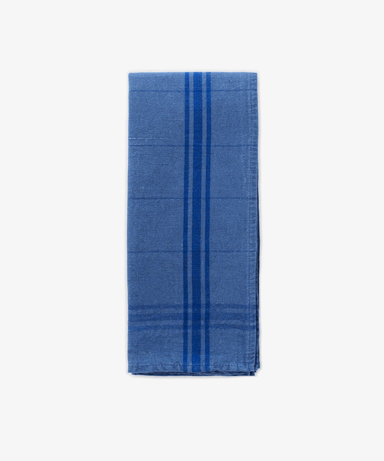 The French Vintage Tea Towel features a folded blue cloth design with two vertical darker blue stripes, evoking classic Provence linen, displayed on a plain white background.