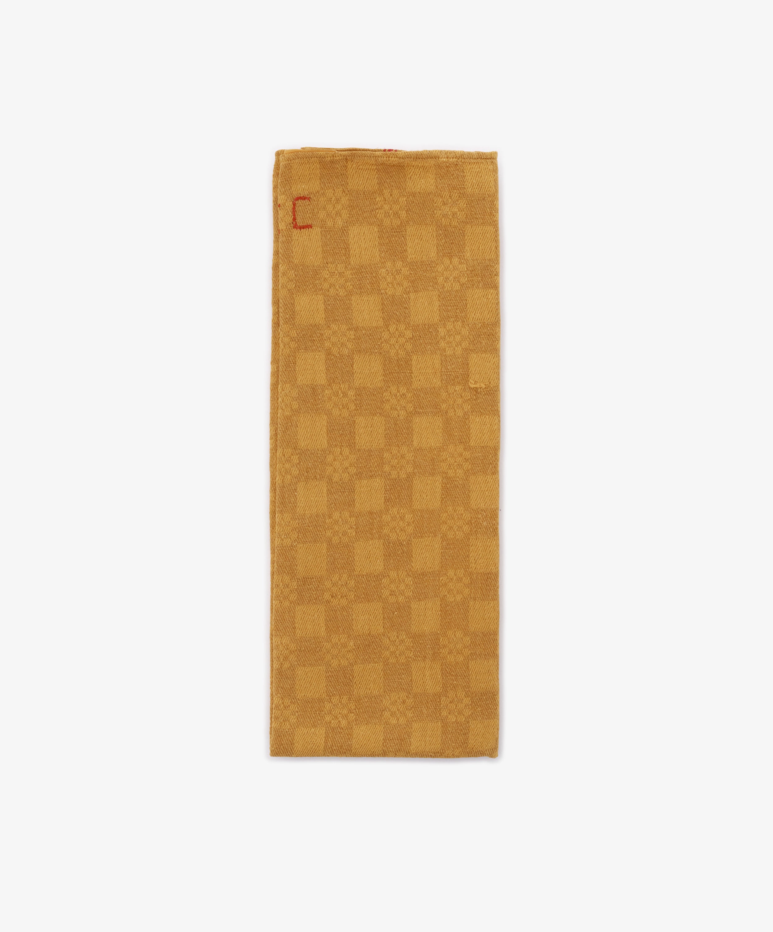 The French Vintage Tea Towel is a rectangular gold napkin featuring a subtle checkerboard pattern and a small red embroidered 