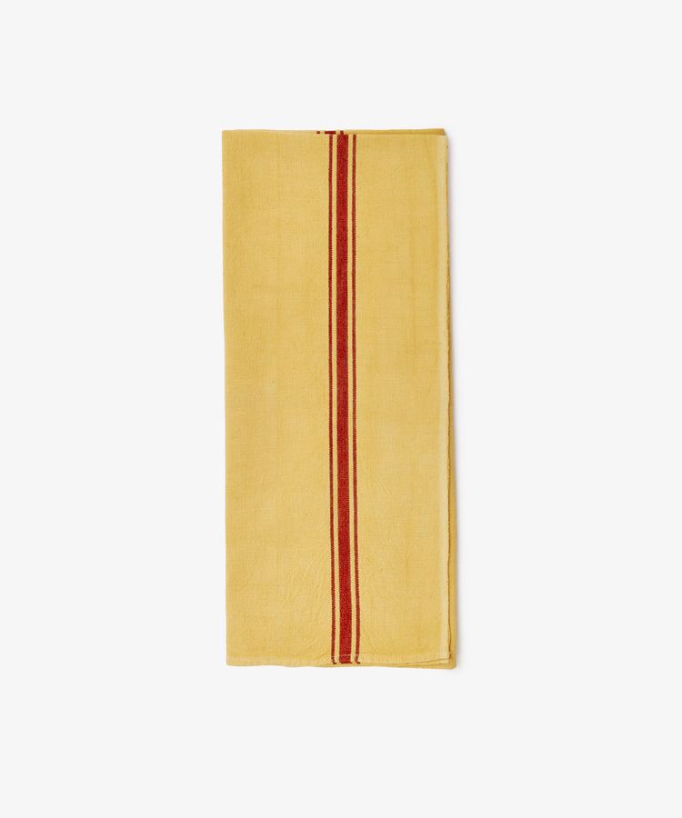 The French Vintage Tea Towel features a folded yellow cloth with a single red vertical stripe, evoking classic Provence style—ideal for adding charm to your kitchen decor.