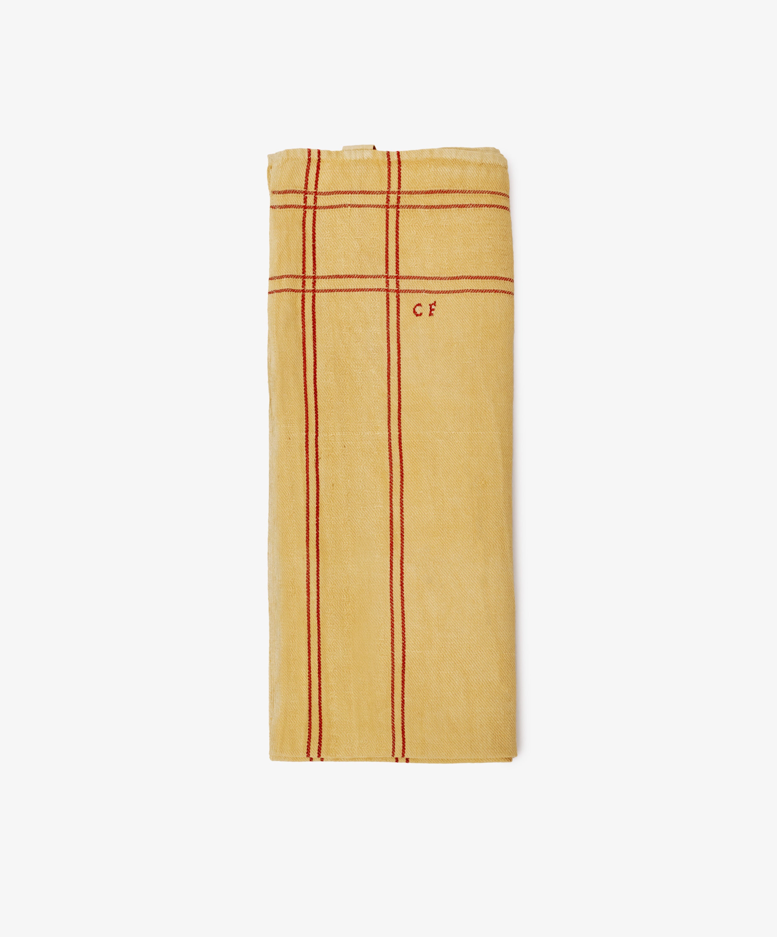 A French Vintage Tea Towel—a folded yellow cloth napkin with red stripes and CF initials embroidered near the top, evoking classic Provençal linen.