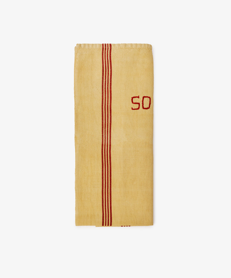 The French Vintage Tea Towel is a folded yellow linen with two red stripes and the number 50 embroidered in red on the right side, adding Provence charm to your kitchen. Shown on a plain white background.