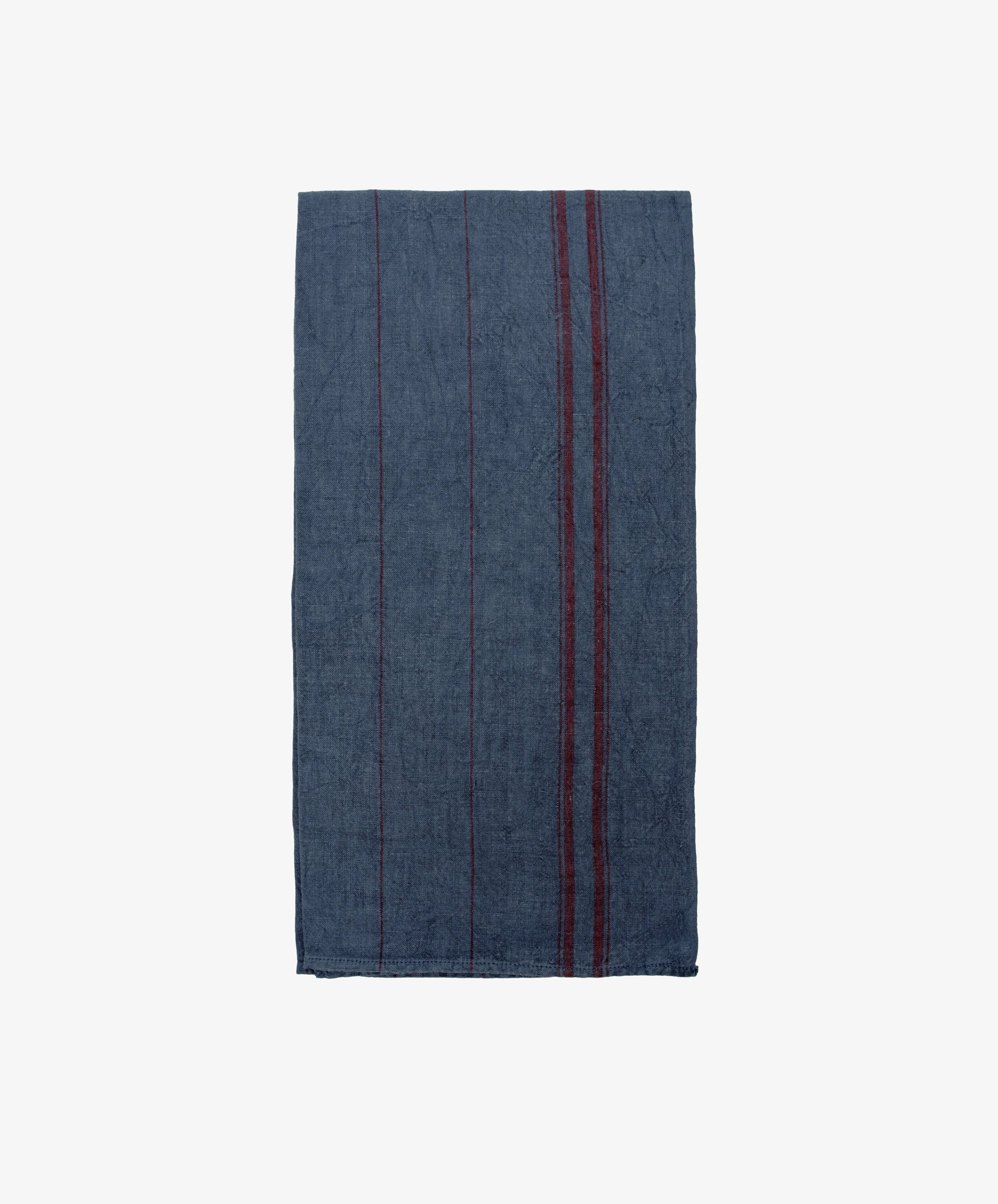 The French Vintage Tea Towel is a dark blue rectangular cloth with subtle vertical red stripes on the right side, inspired by vintage linen tea towels and shown on a plain white background.